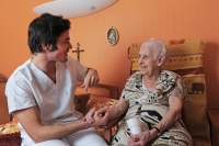 A home nurse serving lunch to an elderly man